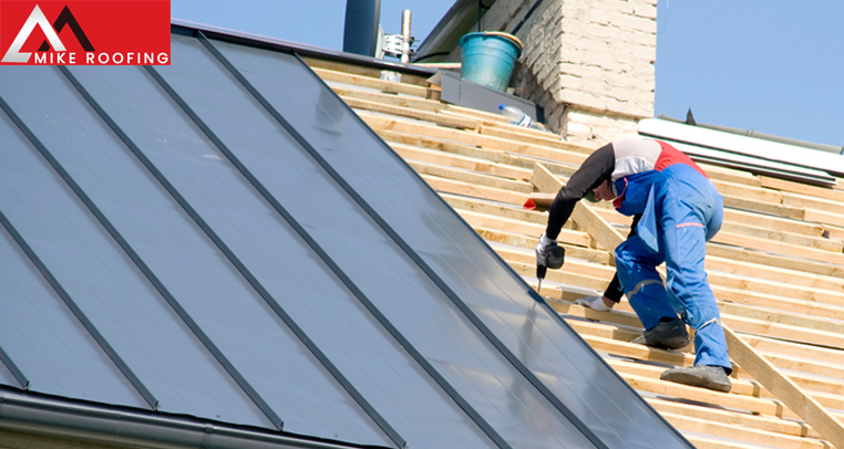 Team of roofers installing shingles on a commercial property