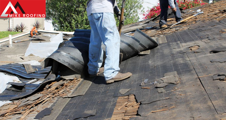 Roofing worker repairing shingles to fix blow-offs after a storm.